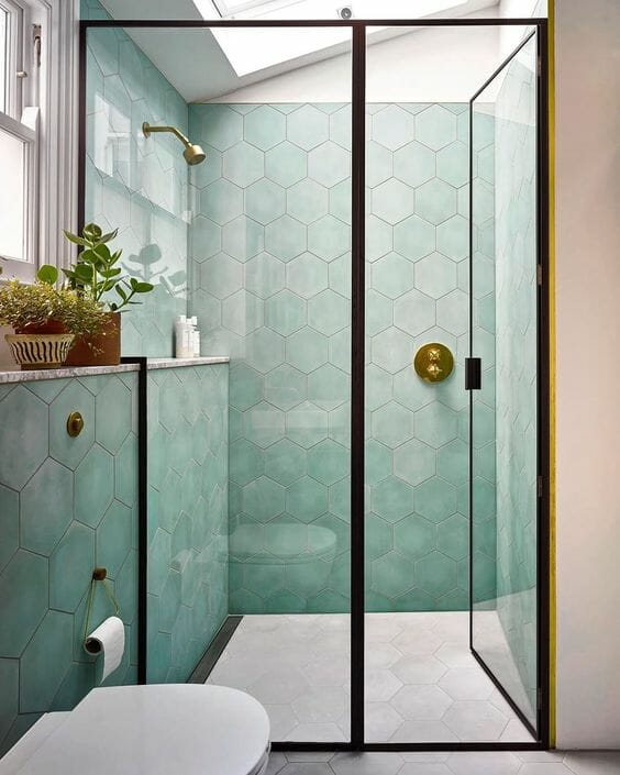 Douche italienne noire avec carreaux de carrelage verts et murs rosés