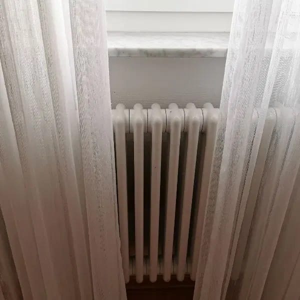 Rideaux longs devant un radiateur style fonte