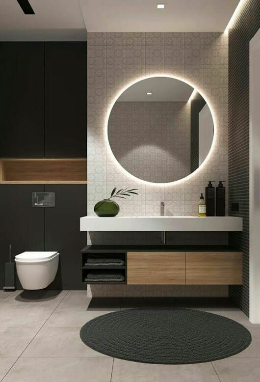 Salle de bain aux tons anthracites et épurés avec grand miroir rond LED