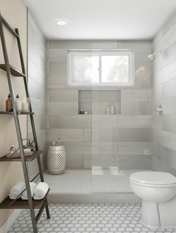 Douche italienne blanche et grise avec grands carreaux de carrelage et niche et étagère en échelle en bois