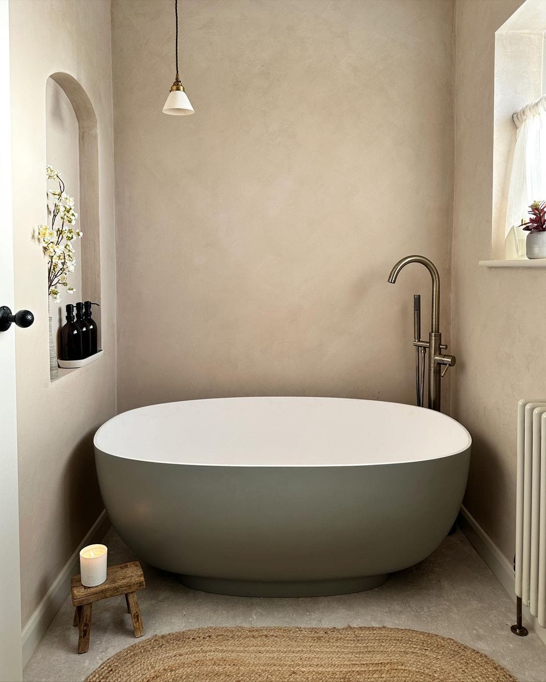 Baignoire îlot dans une niche avec murs beiges et accessoires en bois