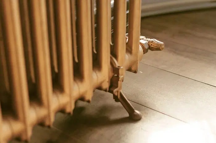 Radiateur rétro à la finition dorée avec pieds et robinet