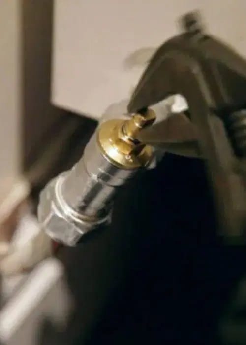 Clé à molette tenant la tige d’un robinet thermostatique