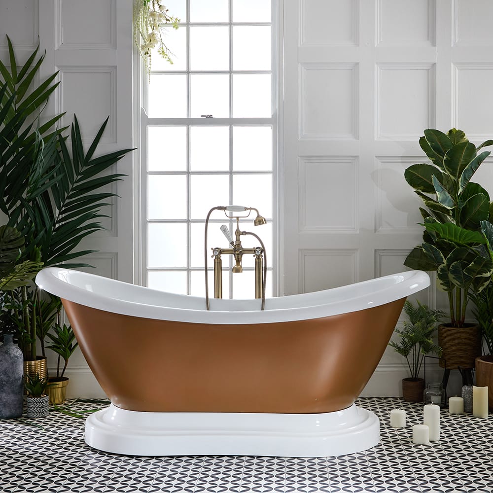 Baignoire îlot en cuivre entourée de grandes plantes vertes