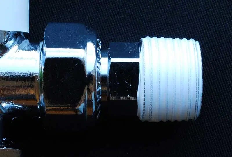 Écrou et tête de robinet enroulé dans du ruban adhésif PTFE