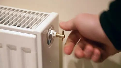 Personne s’appretant à tourner la clé de purge dans le robinet de purge