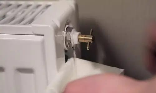 Eau s’écoulant du robinet de purge dans une serviette